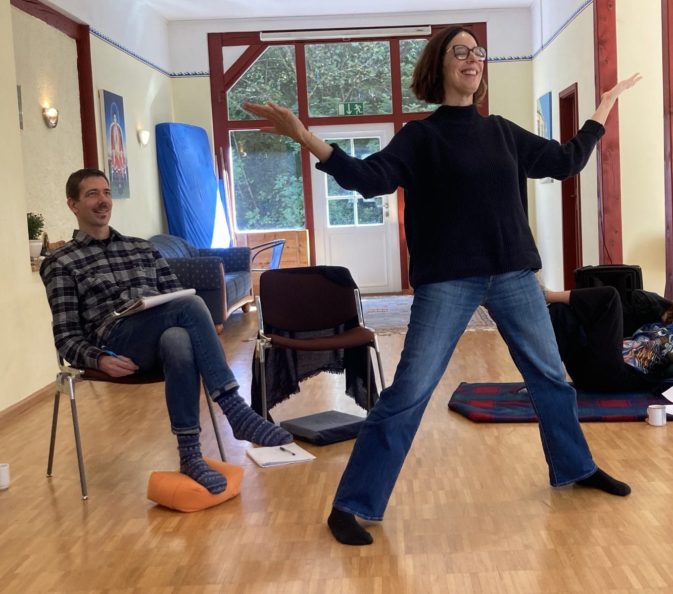 A participant opening her arms wide during an exercise