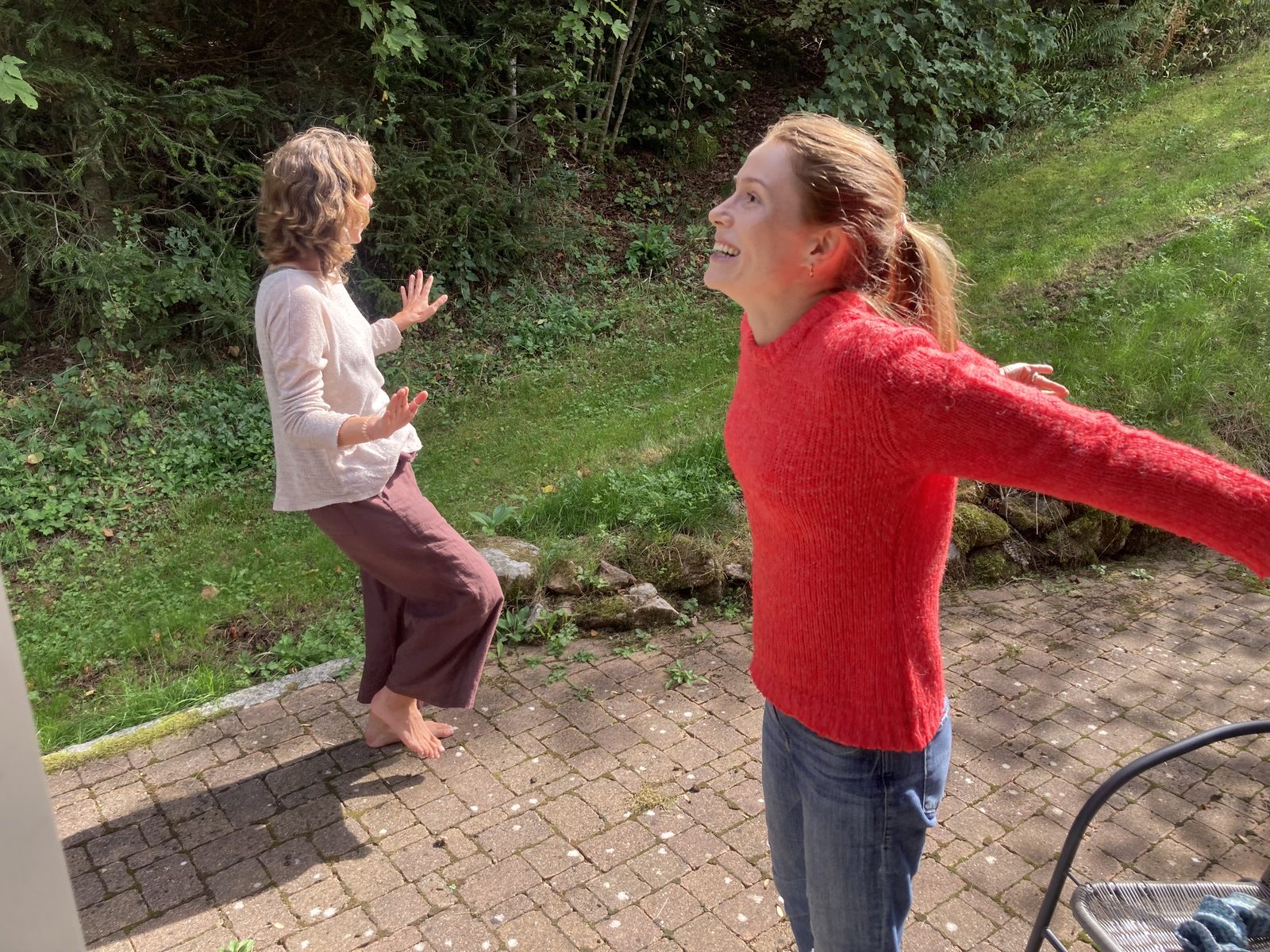 A participant opening her arms with joy in the garden