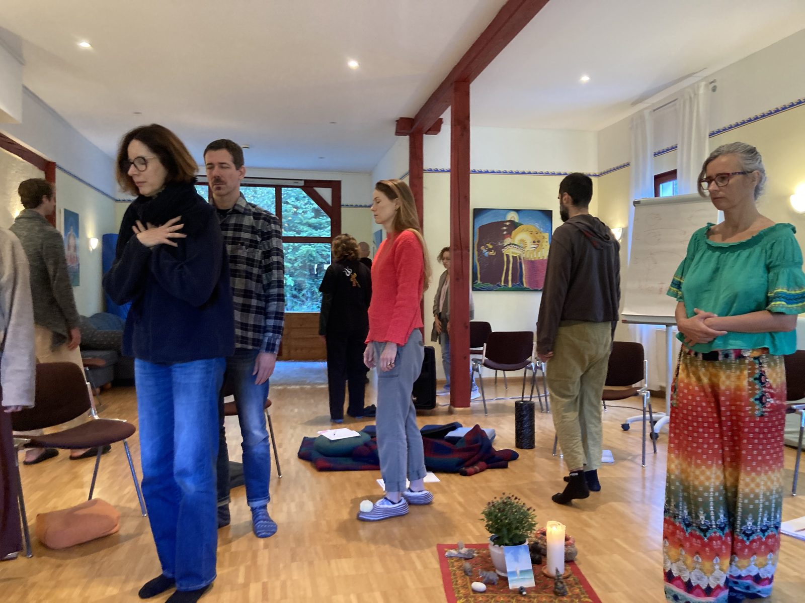Participants standing with hands on their hearts around the centre candle