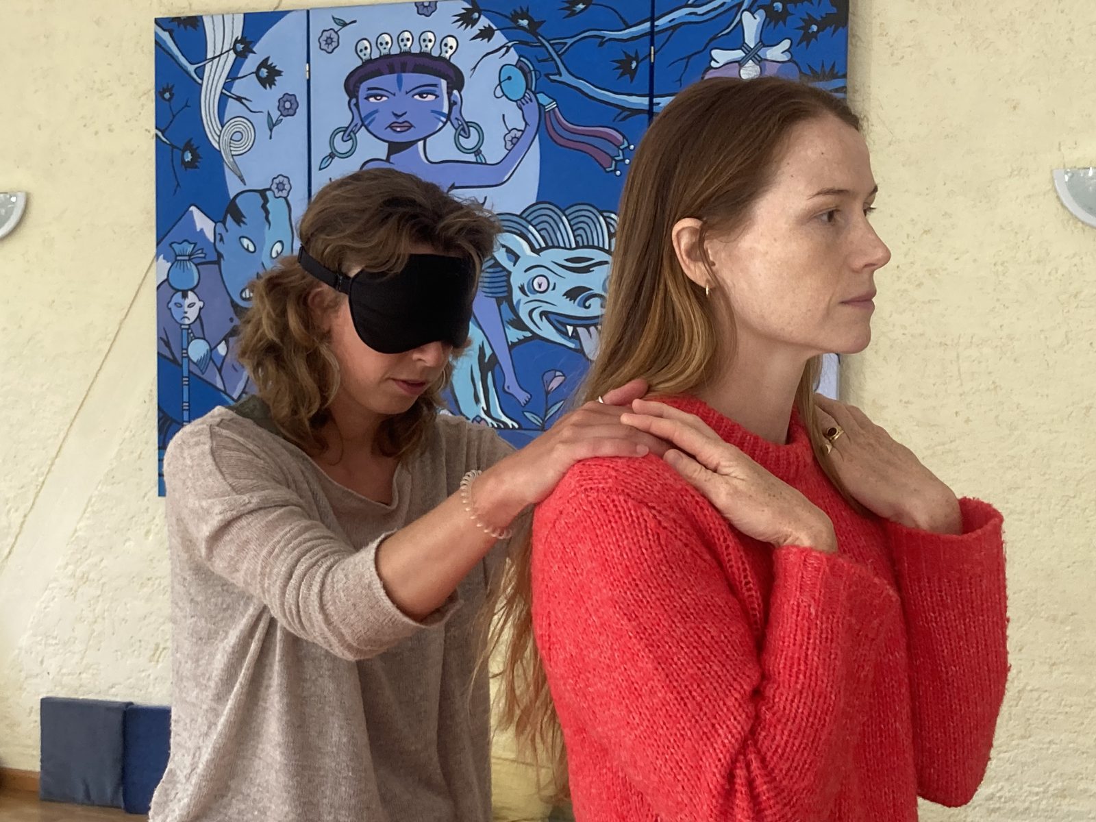 A blindfolded participant placing her hands on a partner's shoulders