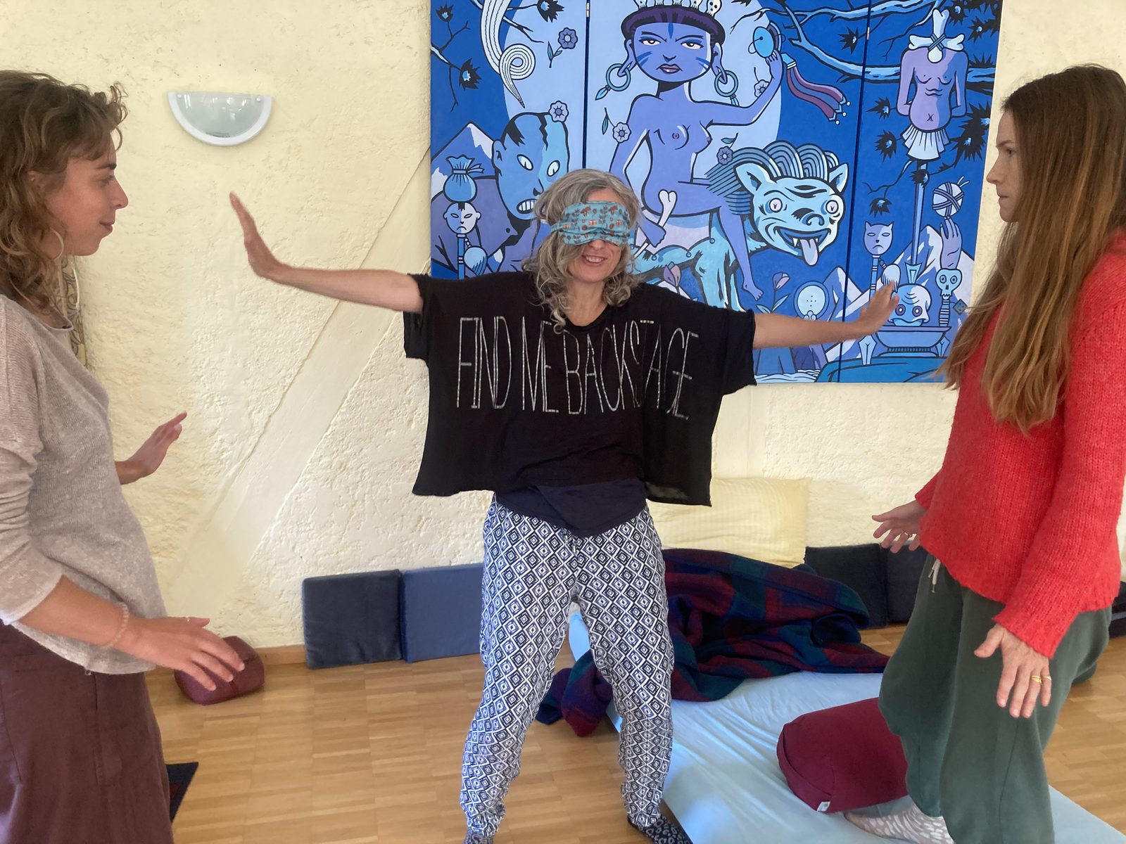 A blindfolded participant pushing outward toward two partners