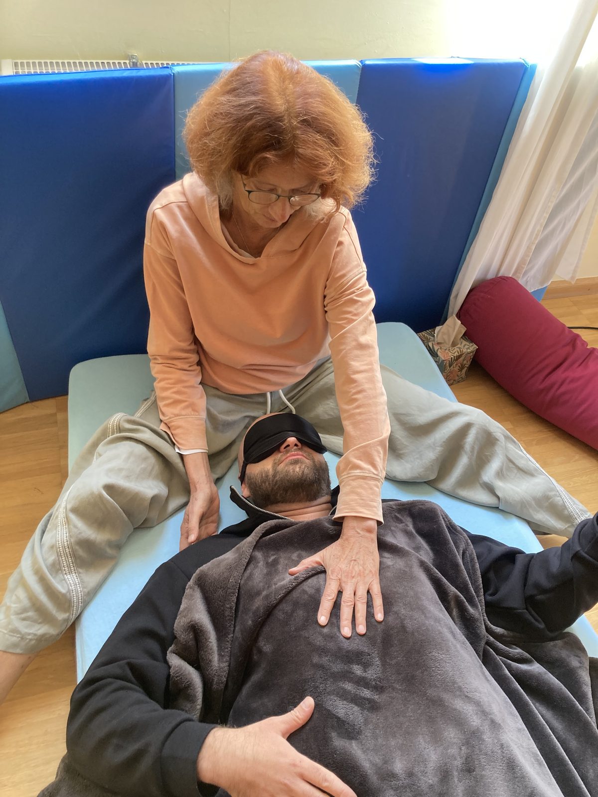 A facilitator resting a hand on a breather's chest