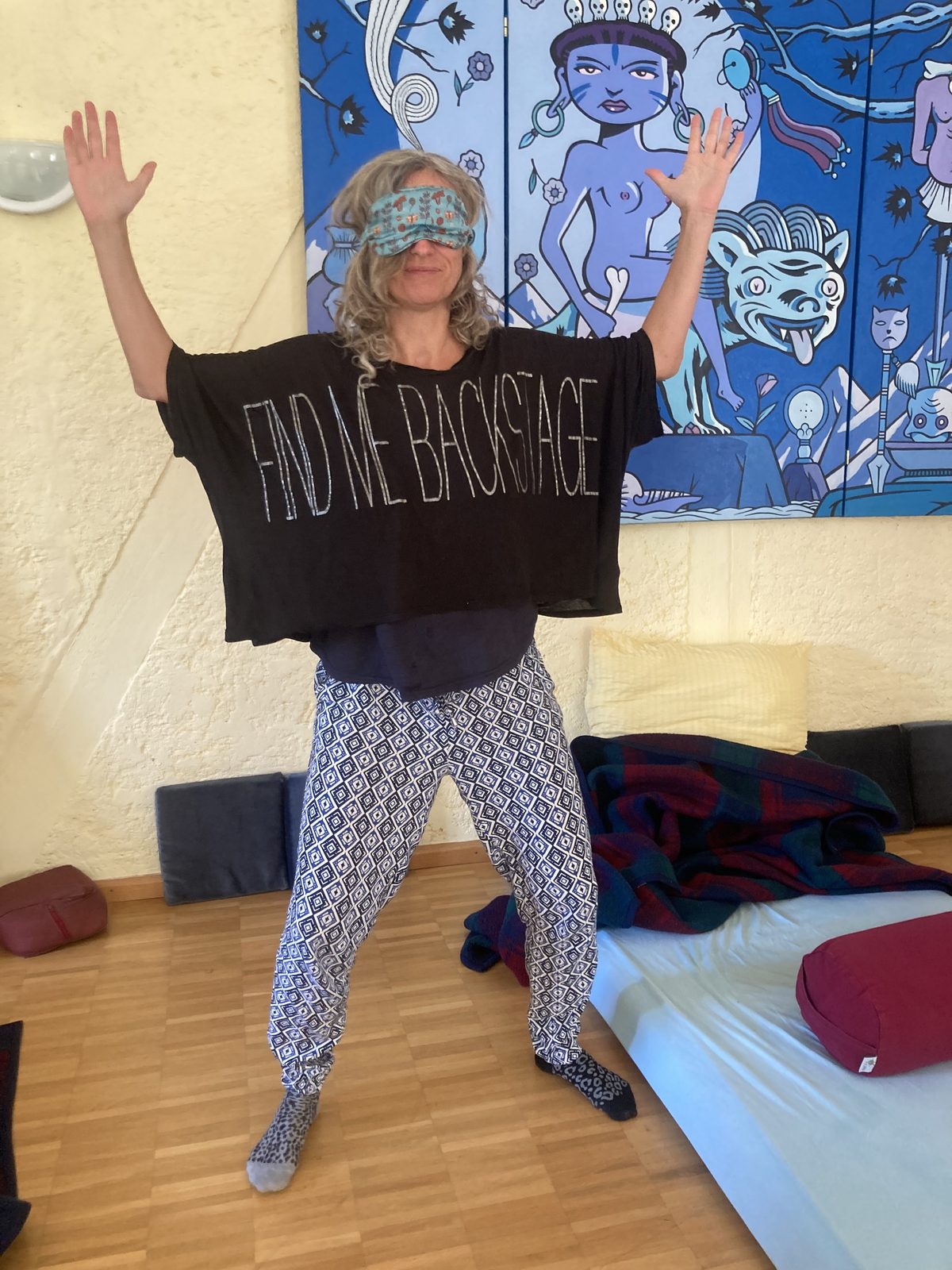 A blindfolded participant raising both arms in a moment of release