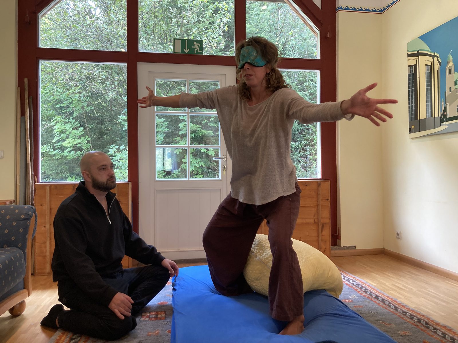 A blindfolded participant stretching her arms wide