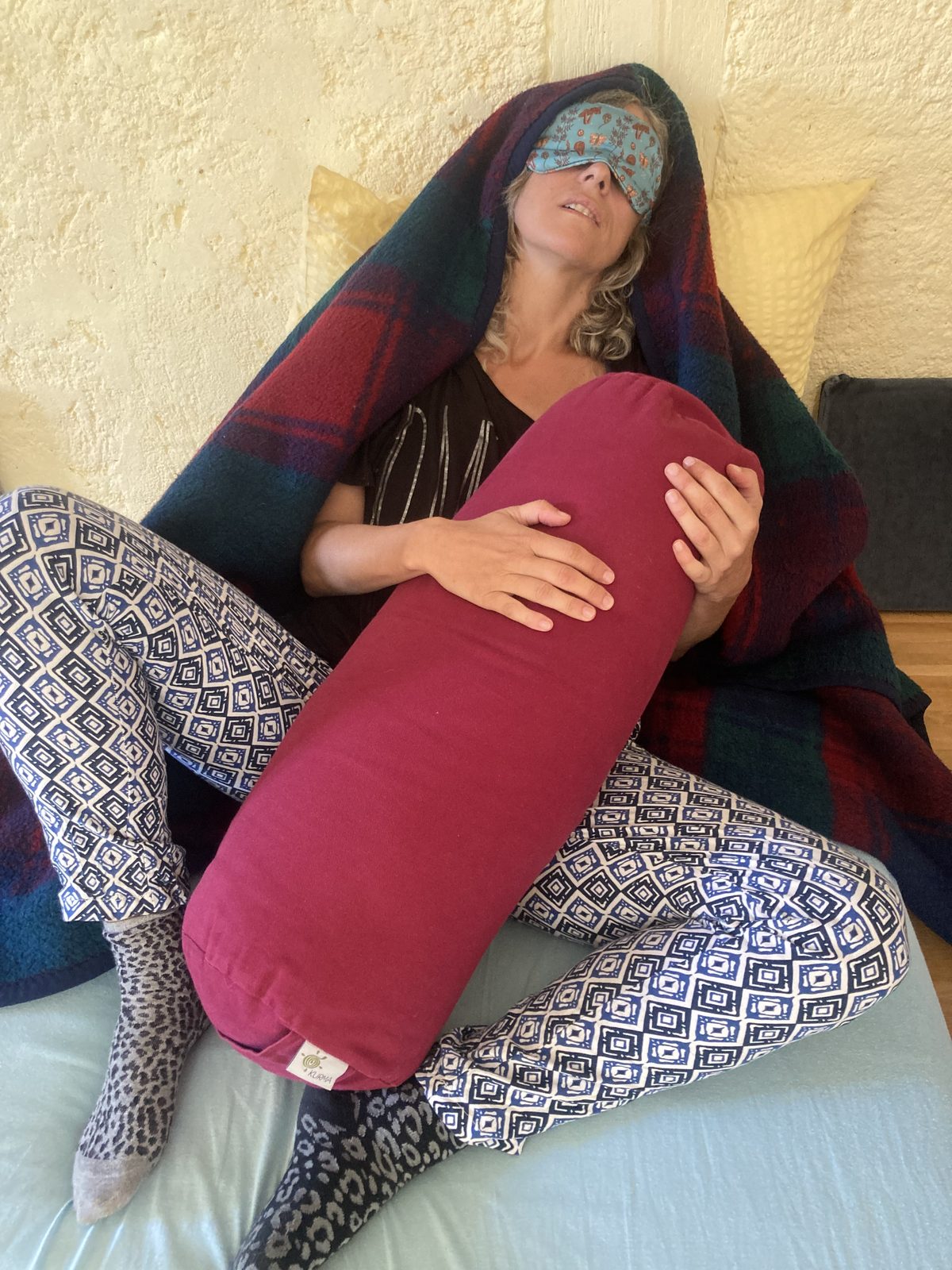 A breather wrapped in a blanket, hugging a bolster